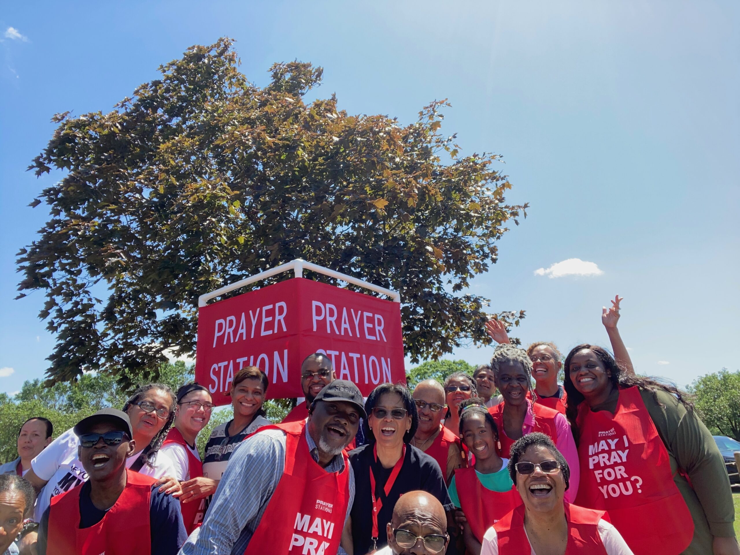 YWAM Philadelphia Prayer Station outreach team smiling together beside a red Prayer Station sign